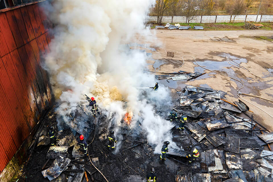 Aerial view of firefighters extinguishing fire before commercial fire damage restoration